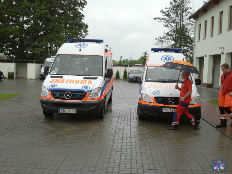 Pada deszcz, ratownicy pod parasolem